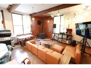 uma sala de estar com sofás laranja e uma televisão de ecrã plano em clubhouse atelier - Vacation STAY 05548v em Shiozawa