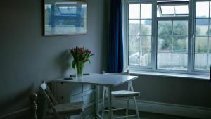 a table and chairs in a room with a window at The Bustard in Salisbury