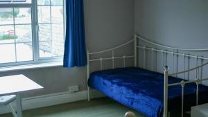 a bedroom with a bed and a desk and a window at The Bustard in Salisbury