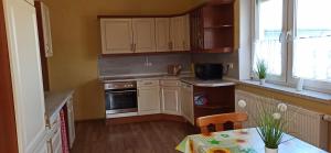 a kitchen with white cabinets and a table and a window at Ferienhaus Fabich Ganzes Haus in Nebelschütz