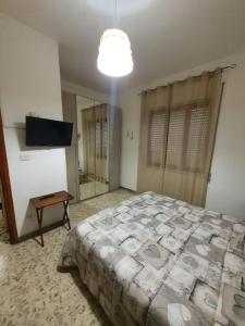 1 dormitorio con 1 cama grande y espejo en Casa Papona en Sezze