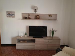 una sala de estar con TV en un centro de entretenimiento de madera en Casa Papona en Sezze