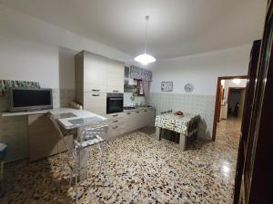 cocina con escritorio, TV y mesa en Casa Papona en Sezze