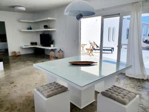 uma sala de jantar com uma mesa de vidro e 2 bancos em Apartamento con vistas al oceano em Tías