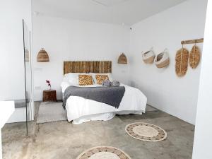 um quarto branco com uma cama e um espelho em Apartamento con vistas al oceano em Tías