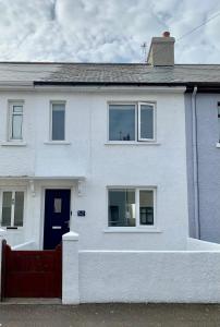 ein weißes Haus mit einem roten Zaun davor in der Unterkunft La Brisa-fully refurbished, perfect local in Portrush + 21 Fotos