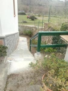 a green rail next to some stairs and a field at Casa la Pontiga in Las Rozas