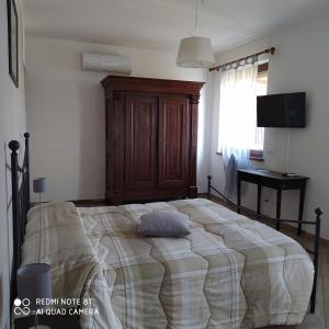 a bedroom with a large bed with a wooden cabinet at Agriturismo La Ca' d'Amelio in Lessolo
