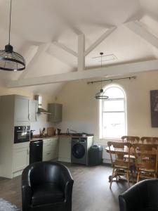 a kitchen and living room with a table and chairs at Wesley Rooms Annexe in Ironbridge