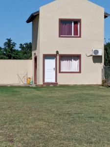 a house with a white door and two windows at Cabañas amaia in Tandil