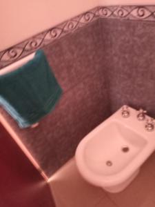 uma casa de banho com um WC e uma toalha verde em Cabaña Amaya em Tandil