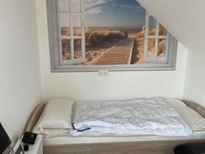 Bett in einem Zimmer mit einem Bild eines Piers in der Unterkunft Gleich hinterm Deich 4 in Friedrichskoog