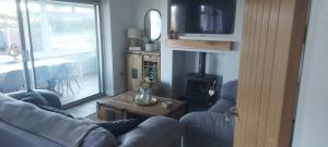 a living room with a couch and a table and a fireplace at Westbourne by the sea, Benllech, Anglesey. in Benllech