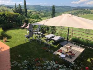 a table with plates of food and an umbrella at Casa Panzano Tuscany in Panzano