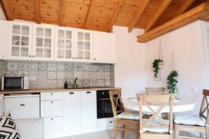 a kitchen with white cabinets and a table and chairs at Samothrakis Michelangelo 301 in Samothraki