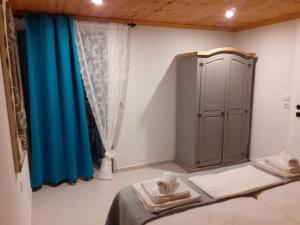 1 dormitorio con cama y cortina azul en Samothrakis Michelangelo 301 en Samotracia