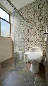 a bathroom with a toilet and a shower at Finca los Colores in Villavicencio