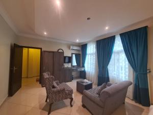 een woonkamer met een bank en 2 stoelen bij روز نيري 2 in Al Khobar