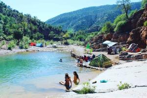 a group of people in the water at a beach at Ocean Surf Lodge in Taghazout