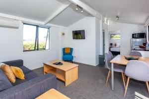 a living room with a couch and a table at Tidewater Motel and Budget Accommodation in Coromandel Town