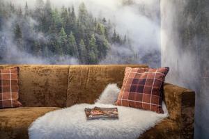 a living room with a brown couch with a blanket at Cima Dodici B&B - Apartments in Sesto