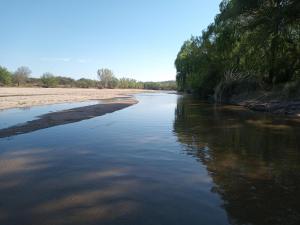 een rivier met bomen aan de zijkant van een strand bij Luz de las Sierras 2 in Arroyo de Los Patos +4 foto's
