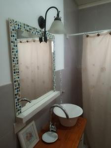 a bathroom with a sink and a tub and a mirror at Luz de las Sierras 2 in Arroyo de Los Patos