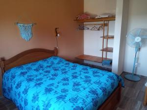 a bedroom with a bed with a blue comforter at Luz de las Sierras 2 in Arroyo de Los Patos