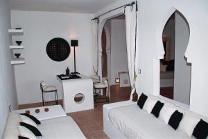 salon z białą kanapą i stołem w obiekcie L'Etoile d'Assilah - La mejor terraza de la medina w mieście Asila