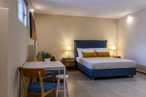 una camera con letto, tavolo e sedie di Blueisla ALPHA Studio Town Mykonos a Mykonos Città