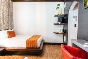 um pequeno quarto com uma cama e uma cadeira em Hotel Chelsea em Miami Beach