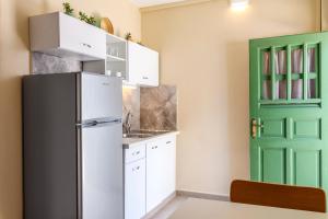 una cucina con frigorifero e porta verde di Blueisla ALPHA Studio Town Mykonos a Mykonos Città