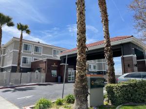 a building with palm trees in front of it at La Quinta by Wyndham Hesperia Victorville in Hesperia