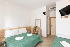 1 dormitorio con cama, espejo y TV en Hotel Morena Riccione Centrale, en Riccione