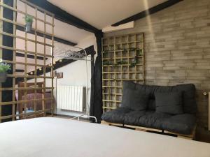 a living room with a couch and a brick wall at La casita de mi abuela in Santo Domingo de la Calzada