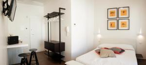 a white bedroom with a bed and a stool at Via Del Faro Apartments in Torre Canne