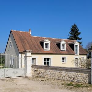 a white house with a gate and a fence at La Prée in Angé