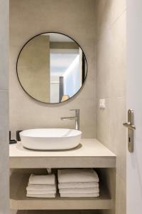 a bathroom with a sink and a mirror at Blueisla GREY Studio Town Mykonos in Mýkonos City
