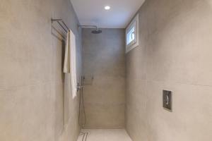 a bathroom with a shower and a window at Blueisla GREY Studio Town Mykonos in Mýkonos City