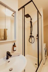 ein Badezimmer mit einem weißen Waschbecken und einer Dusche in der Unterkunft Stilvolles Apartment in ruhiger Lage in Leipzig