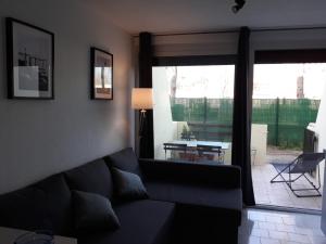 a living room with a couch and a view of a patio at Studio cabine en bord de plage in Marseillan