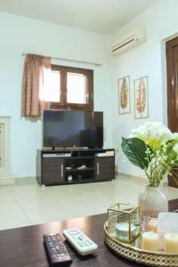 een woonkamer met een tafel met 2 afstandsbedieningen bij Afroditi's Guest House in Heraklion