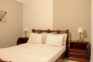 een slaapkamer met een bed met witte lakens en kussens bij Afroditi's Guest House in Heraklion