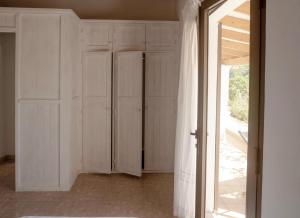 a room with white cabinets and a sliding glass door at Viviendas Ferrer - Formentera Break in Playa Migjorn