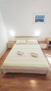a bedroom with a large bed with two pillows at Apartments Vjeko in Split
