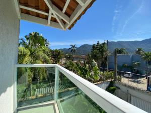 a balcony with a view of the mountains at Sua Casa em Maresias I in São Sebastião