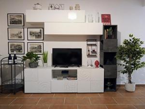 ein Wohnzimmer mit einem TV auf einem weißen Entertainment-Center in der Unterkunft Zisa Home ai Cantieri Culturali in Palermo
