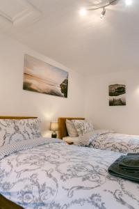 a bedroom with two beds and two pictures on the wall at Crookabeck B&B in Patterdale