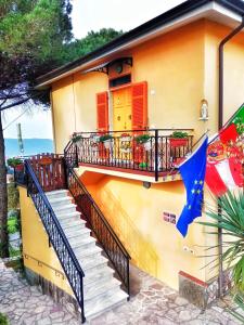 una casa con balcone e bandiera di LA GINESTRA B&B a Fosdinovo