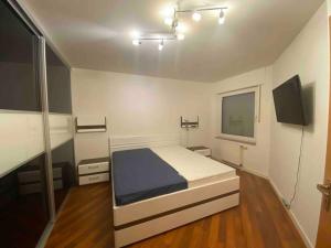 een slaapkamer met een bed en een flatscreen-tv bij Прекрасная квартира со всем необходимым для жизни in Duisburg